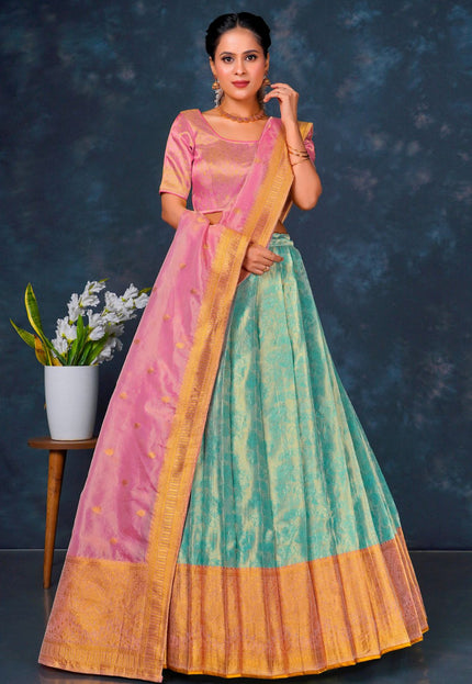 Woman wearing a traditional outfit with a pink blouse and green and orange skirt