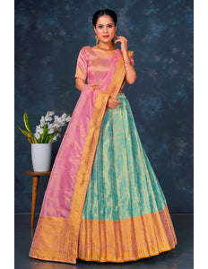 Woman wearing a traditional outfit with a pink blouse and green and orange skirt