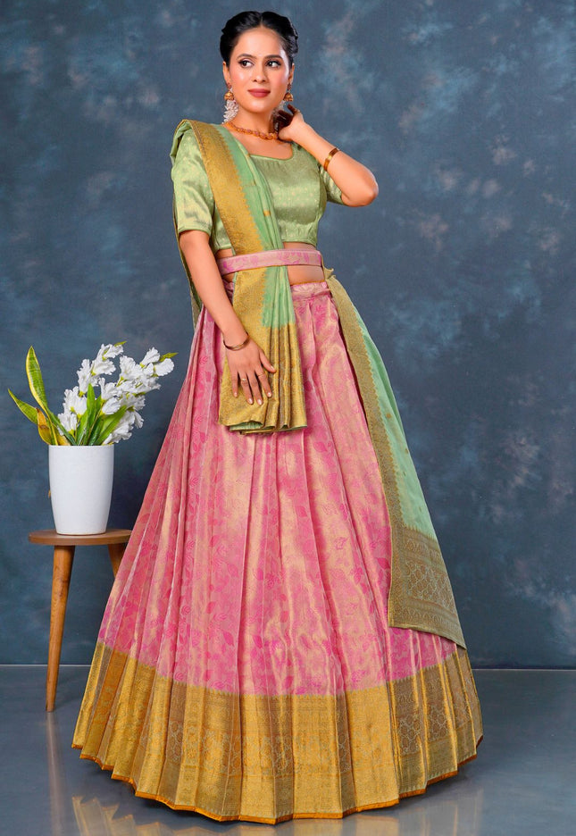 Woman in a traditional outfit with a pink and green lehenga choli