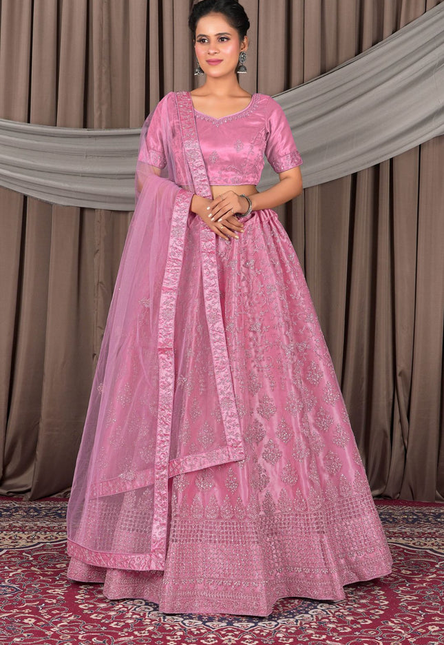 Woman wearing a pink traditional outfit with a matching dupatta
