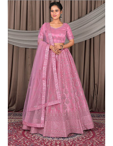 Woman wearing a pink traditional outfit with a matching dupatta
