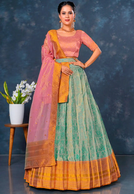 Woman wearing a traditional outfit with a pink blouse and green and orange skirt