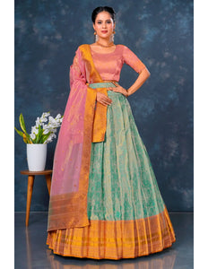 Woman wearing a traditional outfit with a pink blouse and green and orange skirt