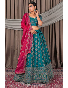 Woman wearing a traditional teal and pink saree with a matching blouse