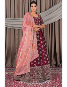 Woman wearing a maroon and pink traditional outfit with a matching dupatta
