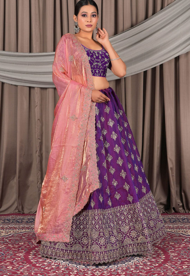 Woman wearing a traditional purple and pink lehenga choli with dupatta