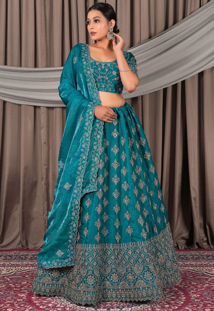 Woman wearing a teal embroidered traditional outfit