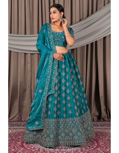 Woman wearing a teal embroidered traditional outfit