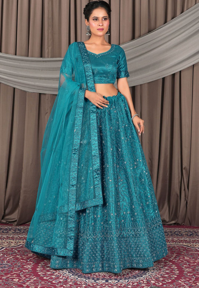 Woman wearing a teal traditional outfit with a matching dupatta