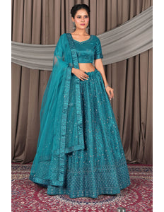 Woman wearing a teal traditional outfit with a matching dupatta