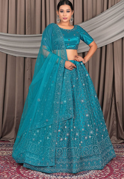 Woman wearing a teal embroidered lehenga with a matching dupatta