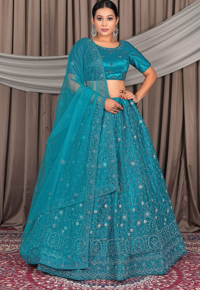 Woman wearing a teal embroidered lehenga with a matching dupatta