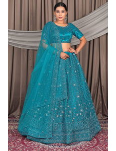 Woman wearing a teal embroidered lehenga with a matching dupatta