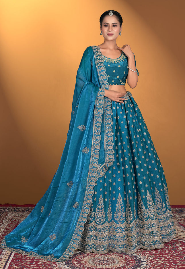 Woman wearing a blue embroidered traditional outfit with a matching dupatta