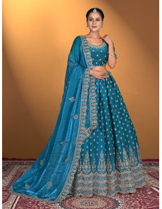 Woman wearing a blue embroidered traditional outfit with a matching dupatta