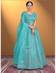 Woman wearing a turquoise embroidered lehenga choli