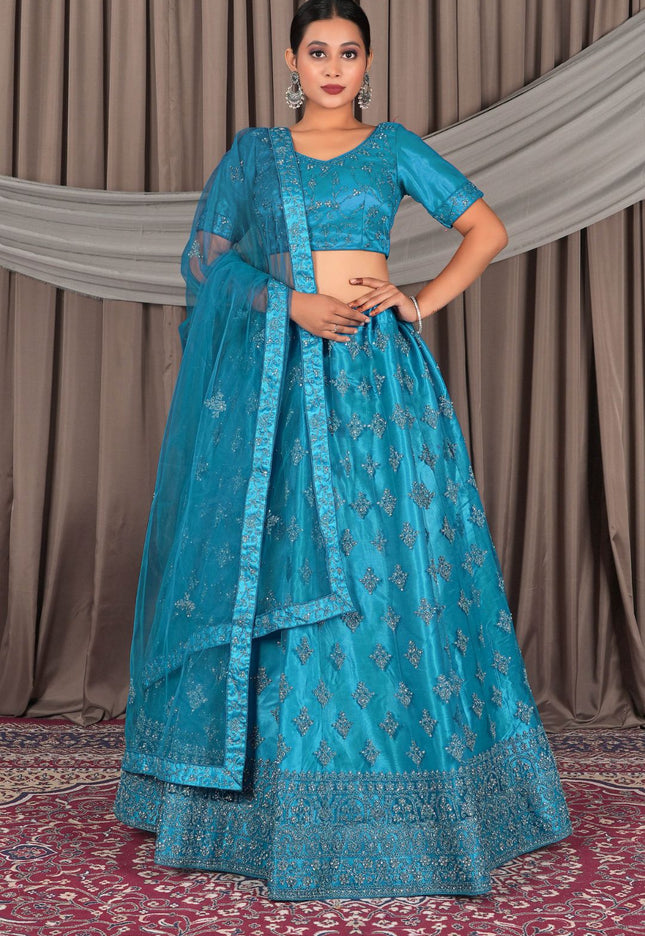 Woman wearing a blue embroidered traditional outfit with a matching dupatta