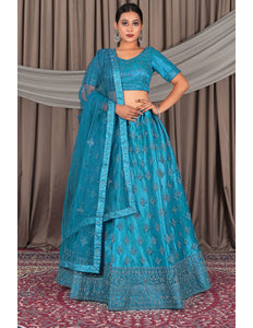 Woman wearing a blue embroidered traditional outfit with a matching dupatta