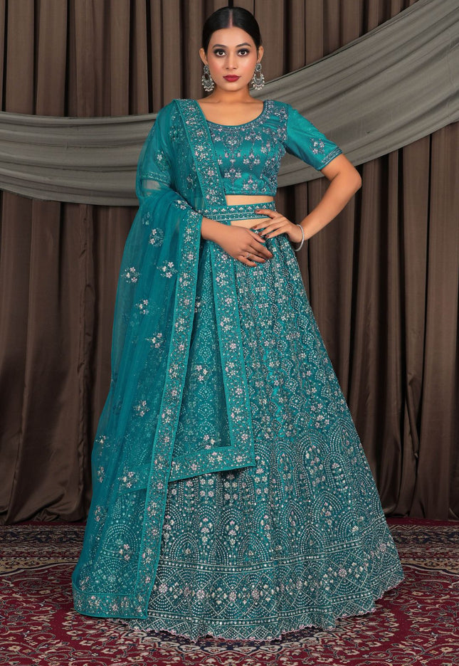 Woman wearing a teal traditional outfit with a matching dupatta