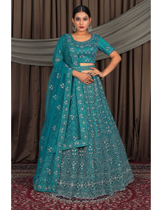 Woman wearing a teal traditional outfit with a matching dupatta