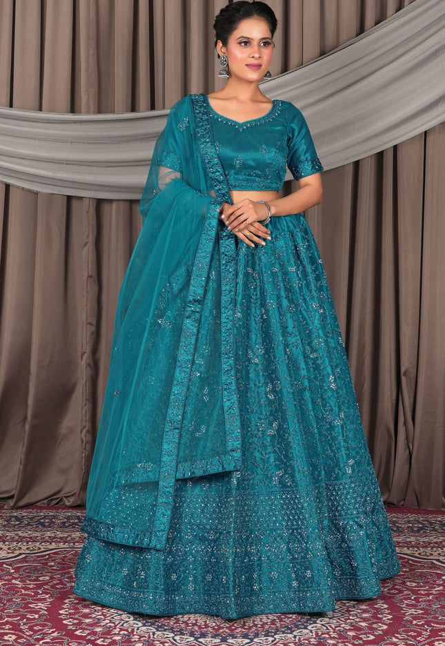 Woman wearing a teal embroidered traditional outfit