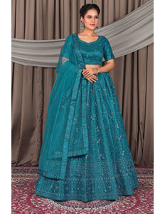 Woman wearing a teal embroidered traditional outfit