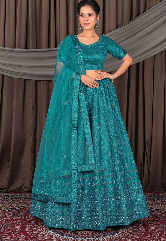 Woman wearing a teal traditional outfit with a matching dupatta