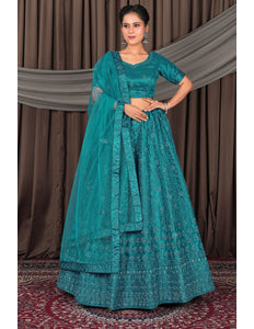Woman wearing a teal traditional outfit with a matching dupatta