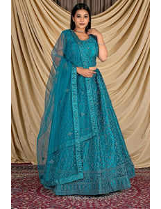 Woman wearing a teal embroidered outfit with a matching dupatta