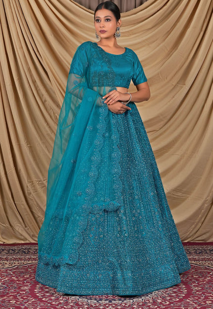 Woman wearing a teal embroidered dress with a matching dupatta