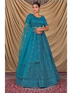 Woman wearing a teal embroidered dress with a matching dupatta