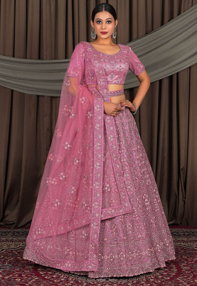 Woman wearing a pink embroidered traditional outfit with a matching dupatta