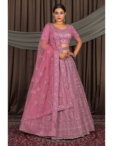 Woman wearing a pink embroidered traditional outfit with a matching dupatta