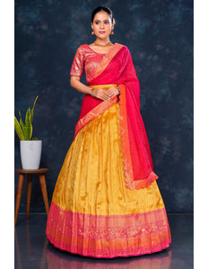 Woman wearing a gold and pink Half Saree with dupatta
