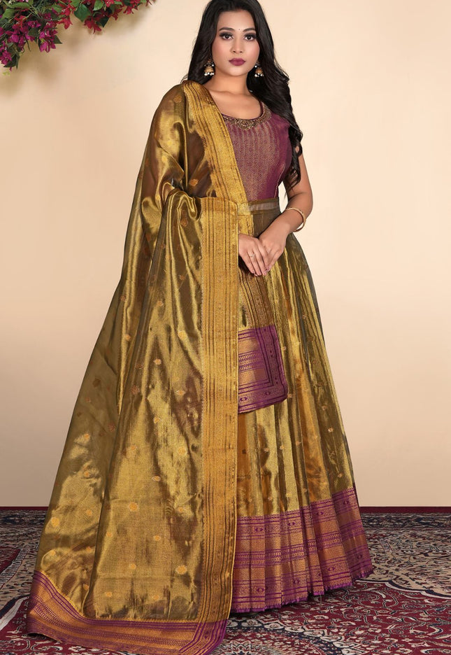 Woman wearing a traditional gold and purple gown with dupatta