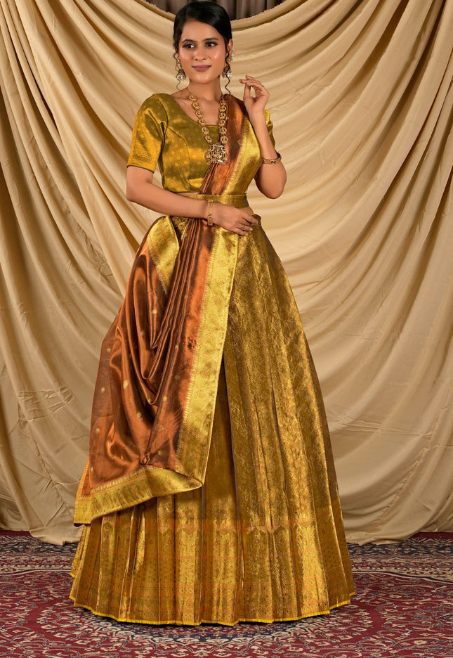 Woman wearing a traditional gold lehenga with a brown blouse