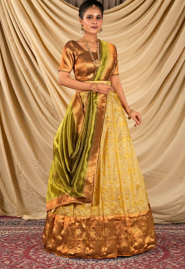 Woman wearing a traditional gold and green lehenga choli with dupatta