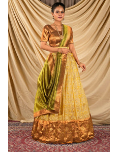 Woman wearing a traditional gold and green lehenga choli with dupatta