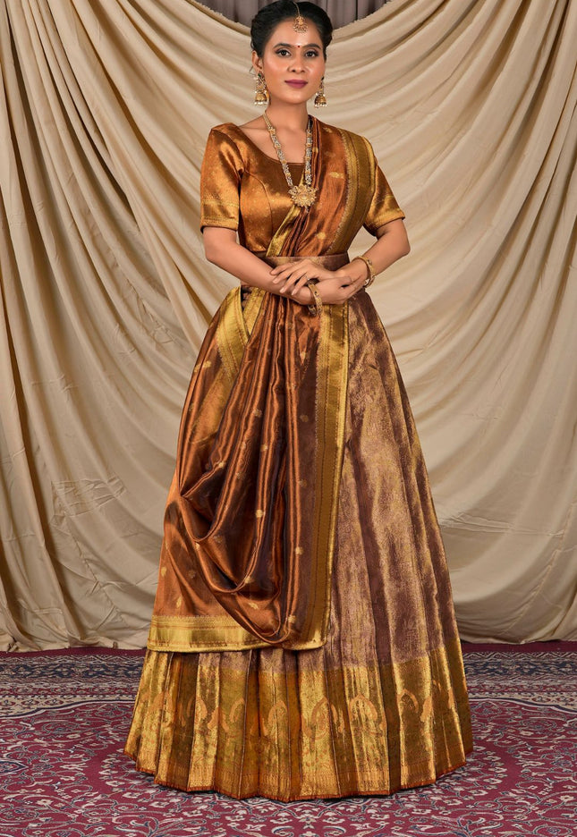 Woman wearing a traditional gold and brown lehenga choli with dupatta