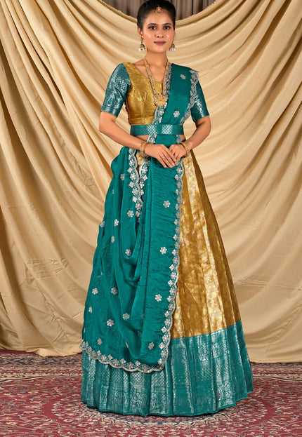 Woman wearing a traditional teal and gold lehenga choli with dupatta