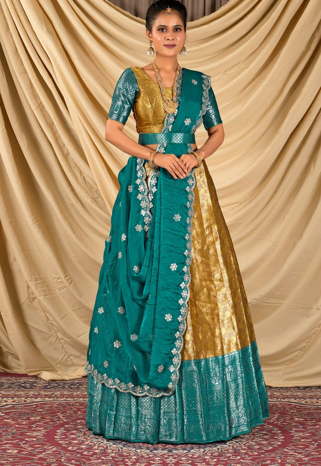 Woman wearing a traditional teal and gold lehenga choli with dupatta