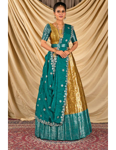 Woman wearing a traditional teal and gold lehenga choli with dupatta