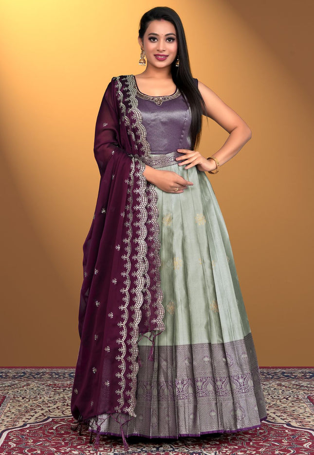 Woman wearing a traditional outfit with a purple and gray gown with dupatta
