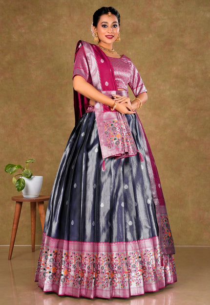 Woman wearing a traditional outfit with a pink blouse and gray skirt