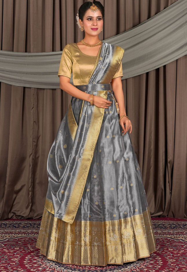 Woman in a traditional gray lehenga and gold blouse with matching dupatta