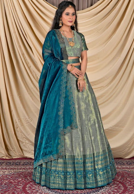 Woman wearing a traditional blue and green lehenga with a matching blouse