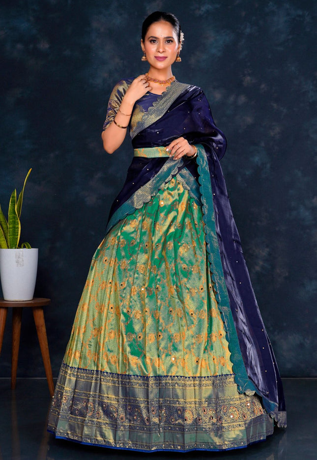 Woman wearing a traditional blue and green lehenga choli with dupatta