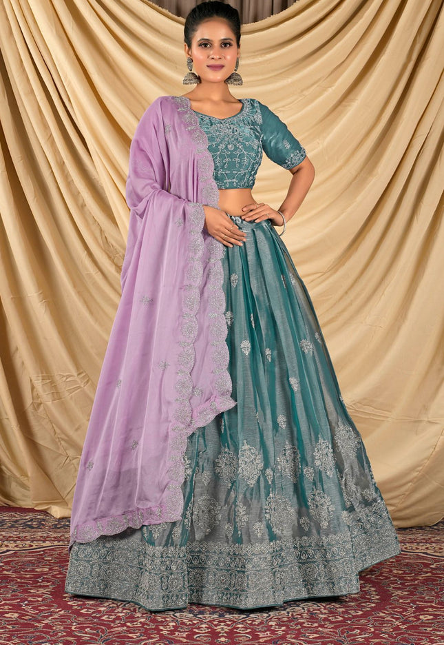 Woman wearing a teal and purple traditional lehenga choli with dupatta