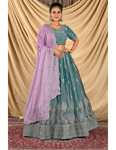 Woman wearing a teal and purple traditional lehenga choli with dupatta