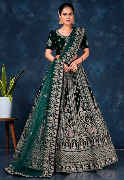 Woman wearing a traditional embroidered outfit with a green dupatta